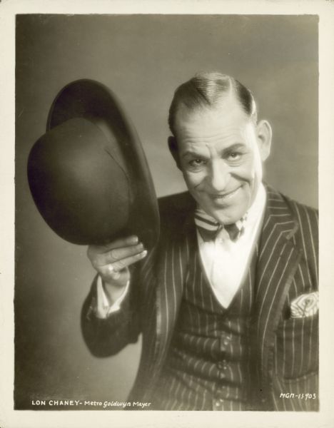 Lon Chaney, as Echo The Ventriloquist, smiling and tipping his hat in a publicity photo for the 1925 film "The Unholy Three."
