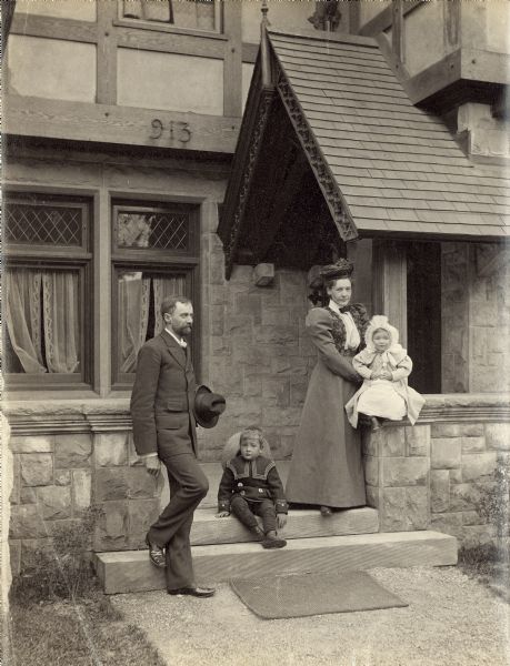 Howard and Louise Greene posing with their young children in front of the entrance of their house at 1831 North Cambridge Avenue.