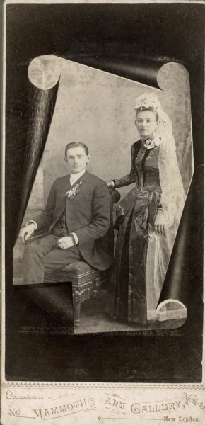Formal portrait of Bernhard Stieg, a pharmacist, & Mary (Dittbermer) Stieg, a milliner, in their wedding clothes. Bernhard is seated and wearing a dark suit with an orange blossom boutonniere. Mary is standing next to him and wearing a dress of golden brown silk with reddish-brown velvet trim and a floor-length veil decorated with orange blossoms.

The couple married in Clintonville, Wisconsin, on December 26,1887.