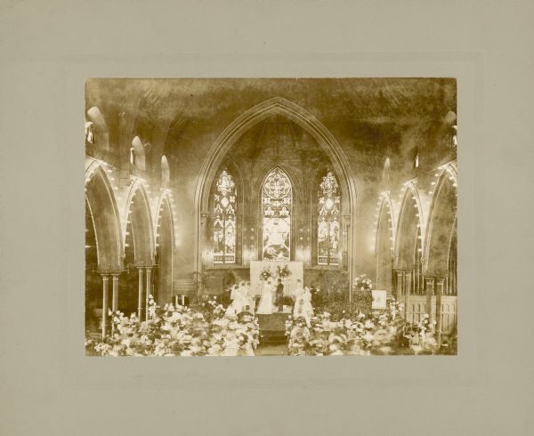 Overview of the wedding ceremony of Mildred Ormsby (1872-1964) and Harrison S. Green, an attorney, at the St. James Episcopal Church, Milwaukee, on the afternoon of June 16, 1897.

According to a newspaper account, Mildred had the church decorated with pink and white peonies and pink ribbons. Her bridesmaids wore dresses of pink net over white taffeta while holding bouquets of sweet peas and maidenhair ferns.