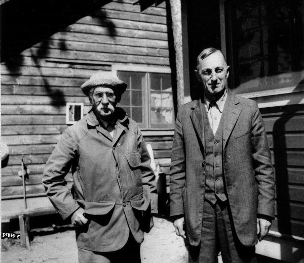 Limnologist Dr. Edward Birge (left) and Professor Chauncey Juday posing together outdoors at what is probably the lake research laboratory in Trout Lake.