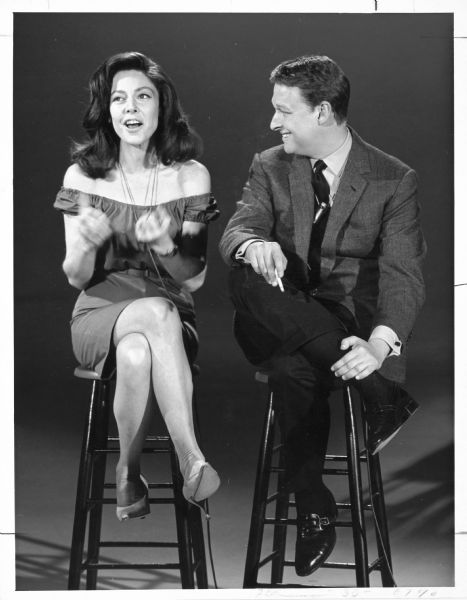 Elaine May and Mike Nichols sitting on stools and performing during an appearance on the Jack Paar Program on NBC.