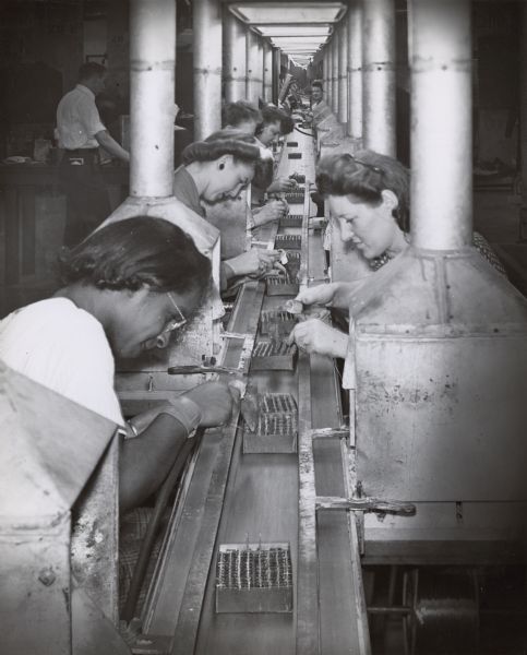 Women cross soldering on a radio line at Ray-O-Vac Corporation.