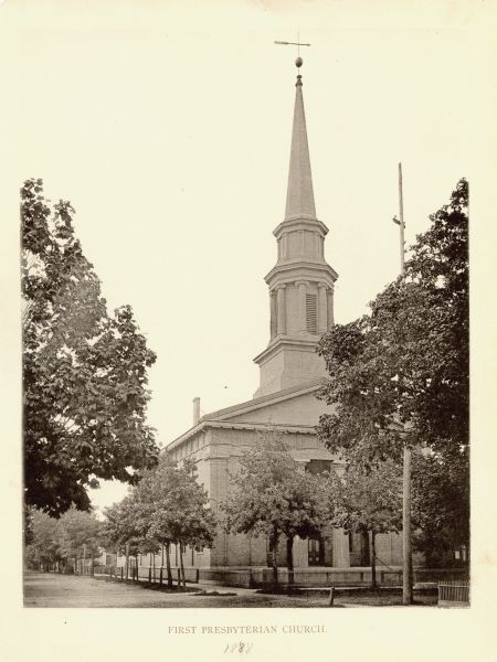 Exterior of church, which is partially obscured by trees.
