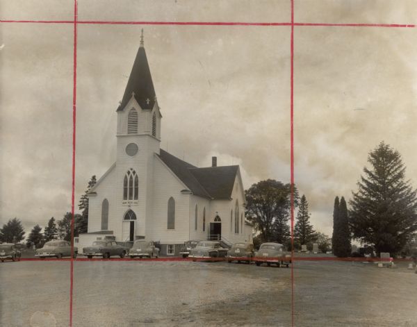 Exterior of church, with cemetery and steeple visible. A sign identifying it as Rush River Luth[eran] hangs over the door. Cars are parked outside the church. An attached article from an unidentified newspaper is titled "Church 100 Years Old - Program Today to End Birthday Fete."