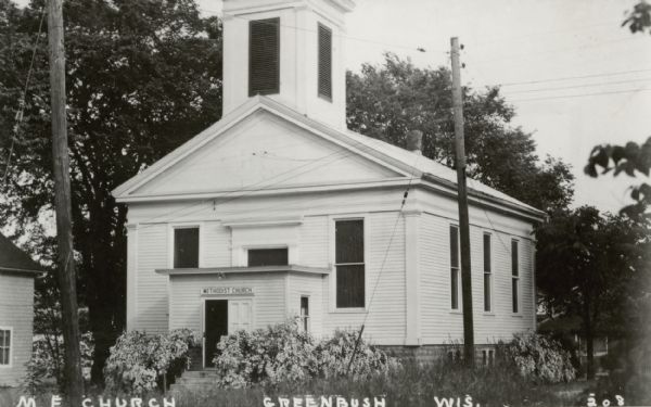 Exterior view of a Methodist church, with a sign that reads: "Methodist Church" over the doorway. 