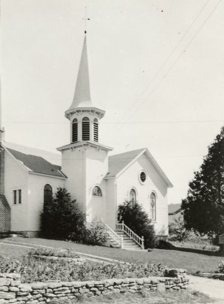 Exterior view of the Ephraim Moravian Church, with steeple. Caption reads: "Moravian Church, Ephraim, Wis. From picture loaned by H. R. Holand."