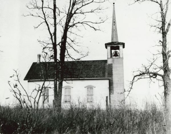 Exterior of a wooden church, with bell tower. Caption reads: "Dane Co., Wis. Danish Lutheran Church, Center Road, Rutland Twp., between Old Stone Road & Old Stage Road. Demolished in 1930. 
