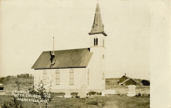 Postcard showing exterior of St. Paul's Lutheran Church, with bell tower and gravestones in yard visible. Caption reads: "St. Paul's Luth. Church, Marxsville, Wis."