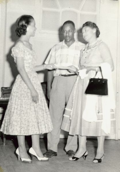 Two women and a man are standing together with a caption that identifies them as "Vel Phillip[s], Bernard Toliver, and Mrs. Moore — 1st prize, Lawn and Garden Contest."