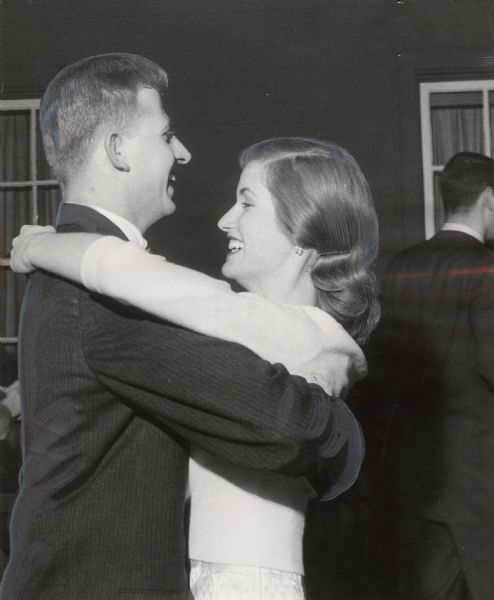 A man and a woman are smiling as they slow-dance. Caption reads: "Among the dancers at Tuesday's tea-dance were James Weber, N. Marietta Av., and Miss Alison Newman, N. Lake Dr."