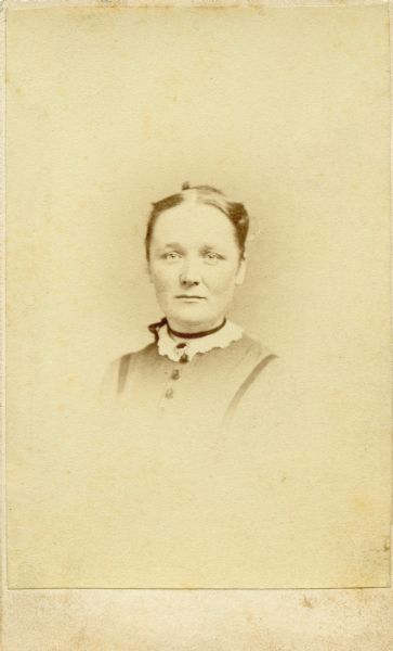 Carte-de-visite quarter-length vignetted portrait of Katherine Schloesser (later Estabrook), dated via caption to "about Civil War time." Schloesser was a Milwaukee resident who became a teacher in the Mississippi Freedmen schools created by the American Missionary Association following the abolition of slavery.