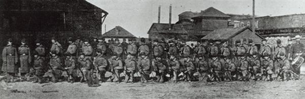 A group of soldiers posing in rows, some kneeling and holding their rifles. Caption reads: "May 1886 Co. F Wisconsin National Guard at Milwaukee riots."