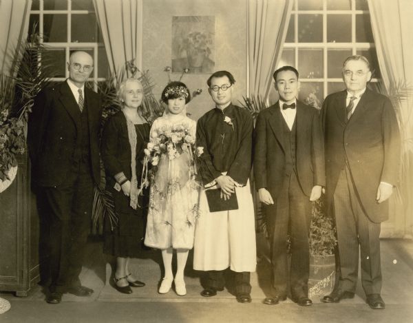 Tou Fong Chu, bride and Tsao Shih Wang, groom, working on a PhD in Political Science at the U.W., are posing with, left to right: Justice Marvin Rosenberry, who married the couple in the first wedding held in the Memorial Union, Dean F. Louise Nardin, the couple, T.K.Pan, best man and Dean Scott H. Goodnight who gave the bride away. 
The back of the photograph is signed: "To Mr. and Mrs. M.B. Rosenberry From Mr. and Mrs. T.S. Wang, July 28, 1929." Includes further annotation in Chinese.