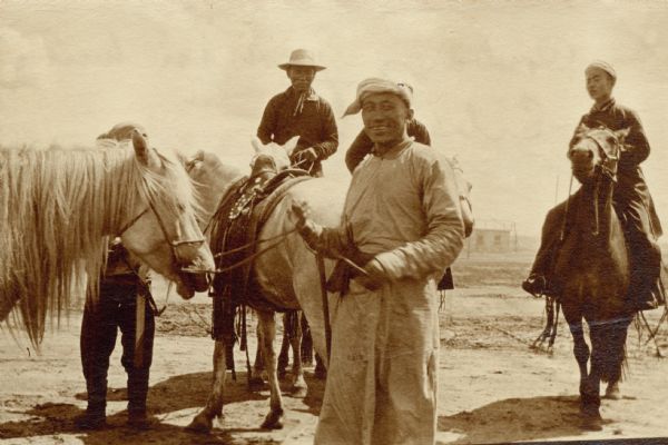 Five men posing with horses. Caption reads: "Cowboys of Manchuria & Siberia."