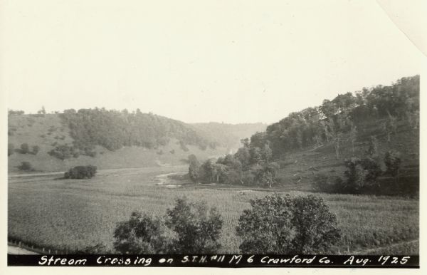 View from hill across a field towards a stream running along the base of a hillside. Caption reads: "U.S. H. 61, Crawford Co. Boscobel-Soldiers Gr. Road. Marietta valley, typical valley of Crawford Co."