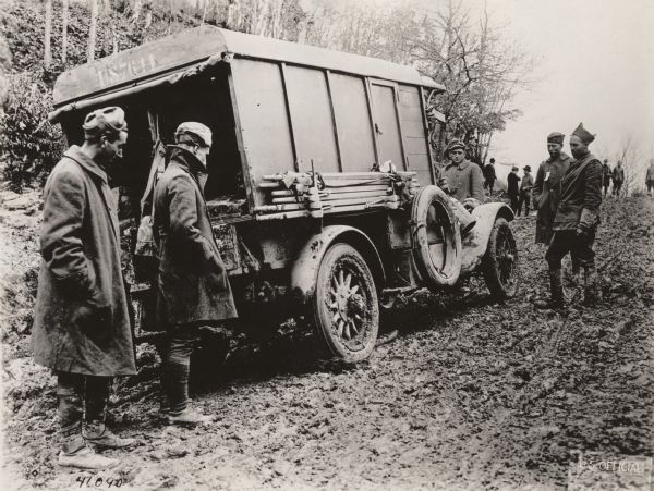 Soldiers looking at ambulance 4, 128th Ambulance Co. stuck on the worst hill on the road to the Rhine. 32nd Division between Buchel and Kaisersesck, Germany.