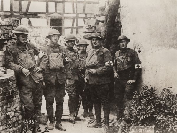 Informal outdoor group portrait of six men from the Medical Detachments of the 127th Infantry, 2nd Battalion, 32nd Division at a first aid station in Eglingen, Alsace, Germany.
