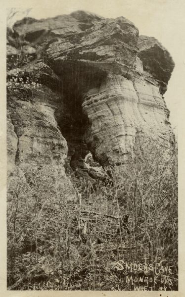 Exterior view of a cave entrance. Caption reads: "Smocks Cave, Monroe, Wis."