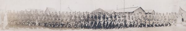 A panoramic group portrait of a military unit at Camp MacArthur. There are buildings and tents in the background. Text on bottom reads: "Officers 56th Regiment, Camp MacArthur, Waco, Texas."