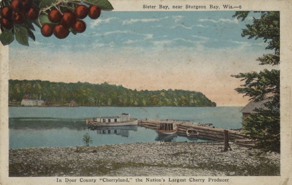 Color postcard view towards the shoreline, with a pier and three boats moored to it. On the far right is a portion of what may be a boathouse. There are buildings on the opposite shoreline. In the upper-left corner of the postcard is an illustration of cherries on a branch. Caption at top reads: "Sister Bay, near Sturgeon Bay, Wis." Caption at bottom reads: "In Door County 'Cherryland,' the Nation's Largest Cherry Producer."