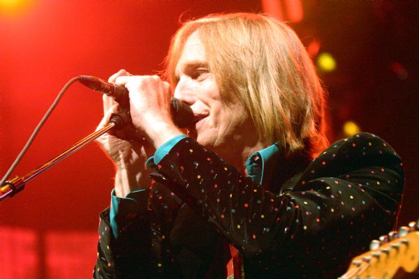 Side view of Tom Petty singing into a microphone during a performance at the Alliant Energy Center with his band Tom Petty and the Heartbreakers.