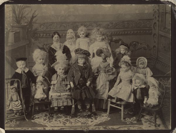 Sixteen dolls are posed together, with some seated and some standing. The caption reads: "Dolls owned by Mrs. Breese J. [Mary Elizabeth Farmer] Stevens, 401 North Carroll Street, Madison, Wis. Exhibition of these dolls in Wis. Hist. Museum, 1909."
[Dolls are identified as:] Margaret Breese, Baby Bess, Violet, Rose, Sydney Stuart, Dorothy, Jenny Watrous, Jack Sanford, Buttercup, Dolly Tuttle, Elizabeth Loomis, Lizzie Miss Vanderbilt, Dottie, Dimple, Betty Blue, Frank, Susie Morris

Merry Christmas, from Elise (Mrs. Reginald H. Jackson, daughter of Mrs. Stevens) 