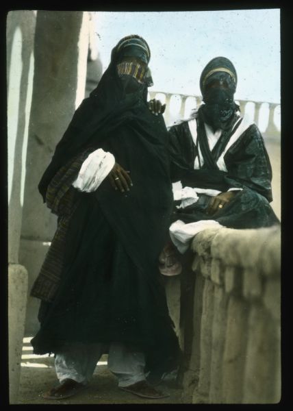 Hand-colored lantern slide portrait of two veiled Tuareg men.