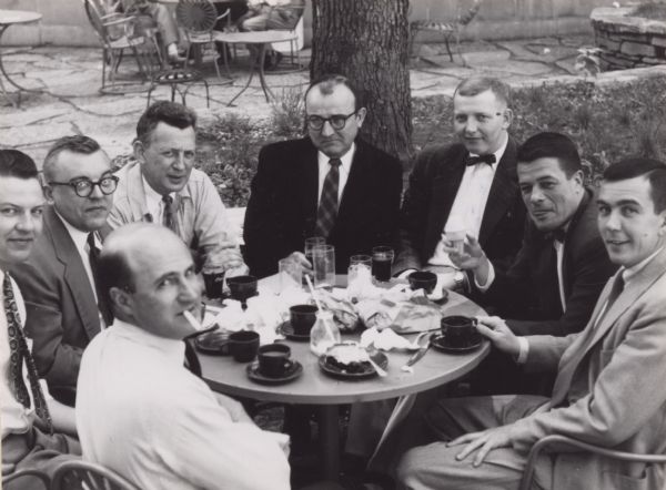 Members of the staff of the State Historical Society of Wisconsin at lunch on the University of Wisconsin Memorial Union Terrace. Foreground, with cigarette, John Jacques; background, left to right: Leonard Bahnke, Keith Hinsman, William Schereck, Edwin Tomlinson, John Colson, Clifford L. Lord (with an ice cream cone), and Don McNeil.