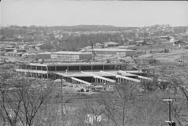 View looking south from the Shorewood bluff of the Hilldale Shopping Center under construction. Apartments and houses in the Hill Farms neighborhood are in the background.