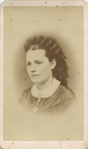 Vignetted quarter-length head and shoulders portrait of a woman.