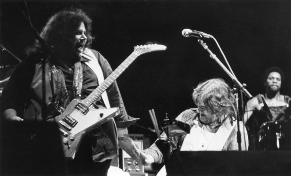 Lowell George (left) gives five to guest musician Leslie West during a performance.