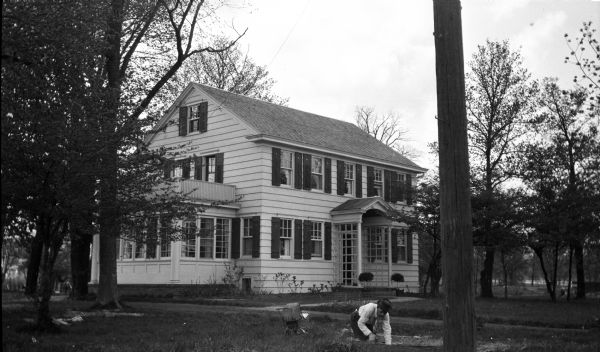 The house at 205 Lakewood Boulevard. A man is working in the yard in the right foreground.