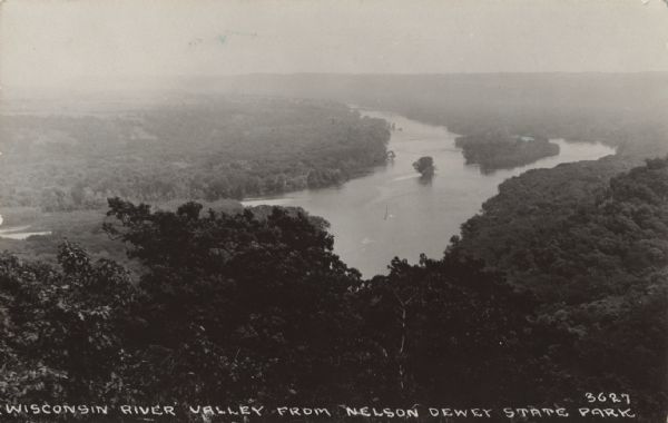 Elevated view of the Wisconsin River Valley, looking down across tree-covered bluffs. Caption reads: "Wisconsin River Valley from Nelson Dewey State Park."