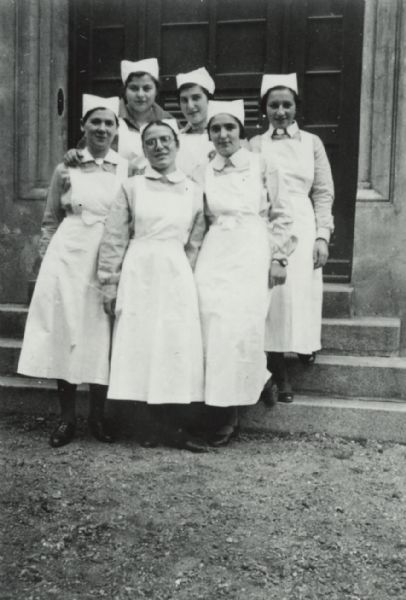 Group portrait of six women posing on the steps of a building. The women are all wearing uniforms that suggest they are nurses or other medical staff. They work at a teaching hospital in Breslau (Wroc&#322;aw), Poland, at which the medical staff was entirely Jewish. The hospital was destroyed in 1938.