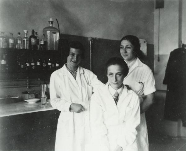 Three women in lab coats posing together. Behind them is a counter and shelves with bottles on them.<p>This was taken at a teaching hospital in Breslau (Wroc&#322;aw), Poland. The medical staff was entirely Jewish. The hospital was destroyed in 1938.</p>