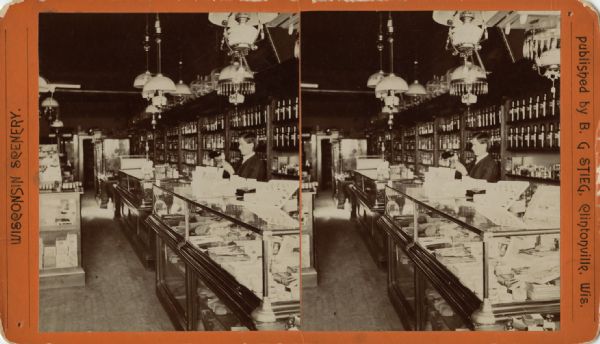 A man is standing behind a counter in a drugstore, pouring liquid from one bottle into a different container. Caption reads: "Bernhard G. Stieg, Pharmacist at F.A. Sedgwick Drug Store, Clintonville Wis."