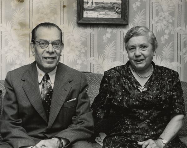 Portrait of a man and woman posing together while sitting on a sofa. A framed artwork is hanging on the wall behind them. Caption reads: "Mr. and Mrs. Ignatius Zavatterri."