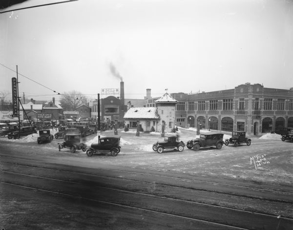 Elevated view of cars lining up at Pennco filling (gas) station at the corner of State and Gorham Streets to get free crankcase draining and "Oak" Motor Oil offered during a winter cold snap.