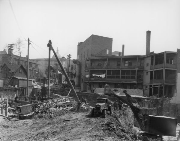The Orpheum Theatre under construction, 216 State Street, looking east at back side of buildings on State Street, with construction workers, truck and steam shovel.