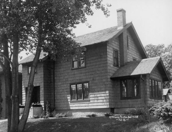 Three-quarter view from right towards the front of the Harold K. Meyers house, at 1910 Vilas Avenue. A house is next door on the left.