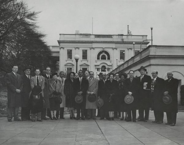 22 people posing together in front of the White House. Caption reads: "CIVIL RIGHTS LEADERS CALL ON PRESIDENT: Pictured on White House grounds is the delegation of leaders of the National Emergency Civil Rights Mobilization who called on President Truman during the three-day Mobilization conference in Washington, Jan. 15-17. Those who attended the White House conference were Roy Wilkins, chairman of the Mobilization and acting NAACP secretary; Elmer Henderson, American Council on Human Rights; Joseph Keenan and Louis Hines, AFL; Felix Cohen, American Jewish Congress; Michael Straight, American Veterans Committee; Charles La Follette, Americans for Democratic Action; Benjamin R. Epstein, Anti-Defamation League of B'nai B'rith; Willard Townsend, CIO Executive Board; Hobson Reynolds, Improved Benevolent & Protective Order of Elks of the World; Adolph Held, Jewish Labor Committee; David Solomon, Jewish War Veterans; Miss Alma Vessells, National Association of Colored Graduate Nurses; Rev. Sandy F. Ray, National Baptist Convention; Thurman Dodson, National Bar Association; Irving Kane, National Community Relations Advisory Council; A. Philip Randolph, National Council for a Permanent FEPC [Fair Employment Practice Committee]; Mrs. I. Lee Levy, National Council of Jewish Women; Mrs. Robert L. Vann, National Negro Publishers Association; Jules Cohen, New York Council for Permanent FEPC; R. A. Hester, Supreme Lodge Knights of Pythias; Roy Reuther, United Automobile Workers; Boyd Wilson, United Steelworkers of America, CIO; Thomas C. Allen, Federal Council of Churches of Christ in America; and Arnold Aronson, General Secretary, National Emergency Civil Rights Mobilization."