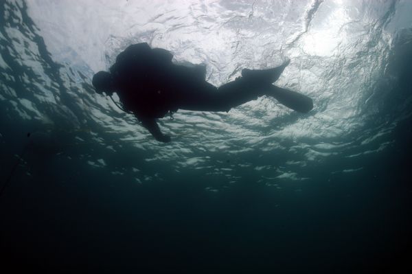 View from below of an archaeologist diving toward the wreckage of the <i>Appomattox</i>.