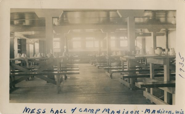 View between rows of tables inside the mess hall of Camp Madison. This was the Civilian Conservation Corps (CCC) camp created at the Arboretum of the University of Wisconsin. The camp was designed by A.E. Galistel.
