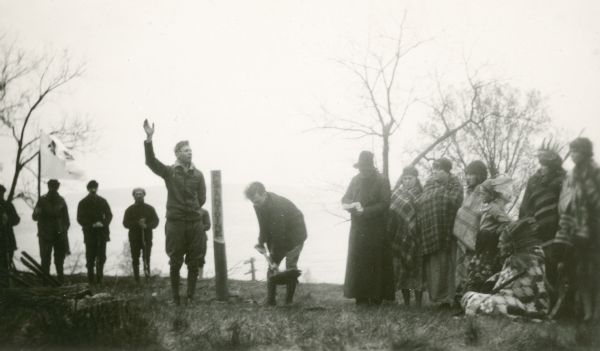 Actors performing in a reenactment of a ceremony in which Nicolas Perrot claimed the territory of the upper Mississippi River for France at Fort St. Antoine. The actor portraying Perrot has his arm raised.