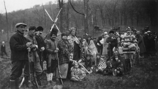 A group of actors posing outdoors together in costume. They are participants in a reenactment of a ceremony in which Nicolas Perrot claimed the territory of the upper Mississippi River for France at Fort St. Antoine. 