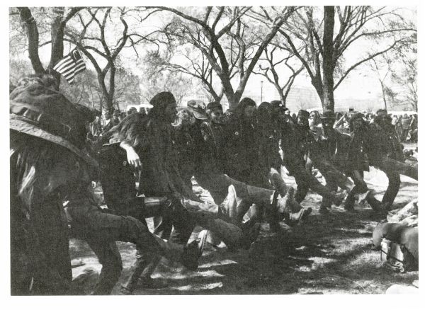 Vietnam veterans dancing in a line outdoors.