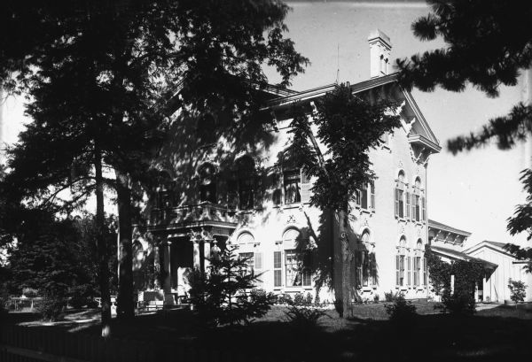 View from intersection towards a residence on 4th and Green Street. The large house shows many Italianate architectural details, including ornate eaves brackets and decorative arches above the windows.