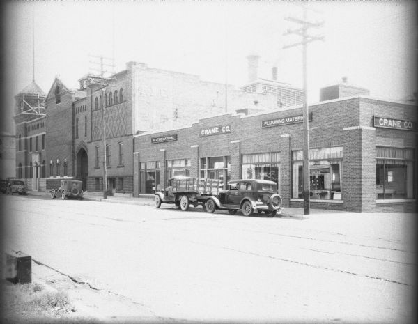 View across street from southwest towards the 600 block of Williamson Street, showing the Fauerbach Brewery at 651-653 Williamson Street, and the Crane Co. with signs for "Heating Material" and "Plumbing Material" at 645 Williamson Street.