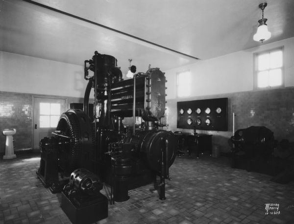 Interior of pumphouse for City of Madison well no. 4, 5 N. Randall Avenue, showing the Electric Machinery Co. motor driven by Sullivan angle compound air compressor and an airlift. Water is pumped into the mains with an Allis-Chalmers motor driven horizontal centrifugal pump.